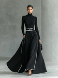 Renata – Vestido Maxi Negro con Costuras Blancas, Cuello Alto, Manga Larga y Cintura Ceñida